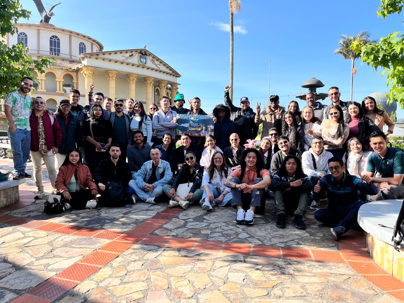 Large Rebel Business School cohort gathered in a town plaza after a program