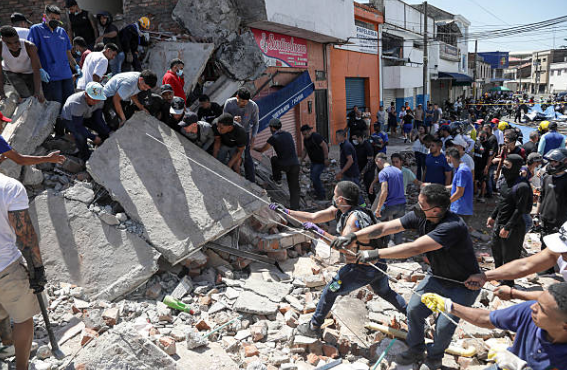 Neighbours and rescue crews clearing rubble from a collapsed commercial street after the earthquake in Colombia